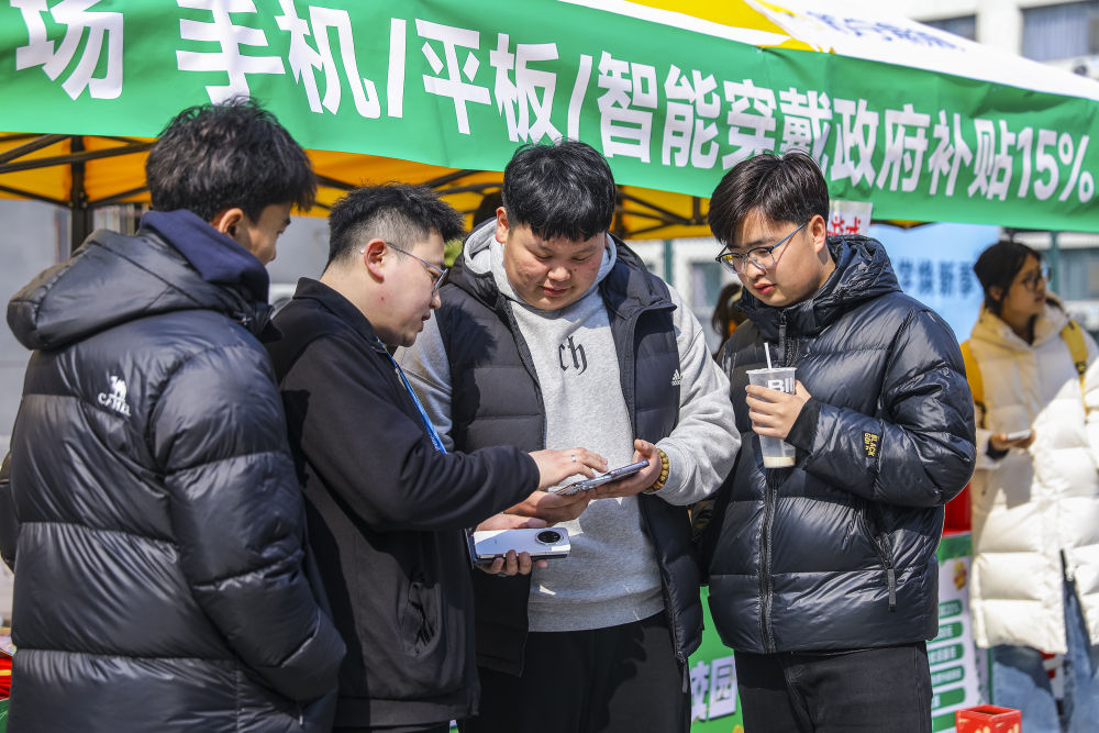 2025年3月6日，学生在山东省青岛恒星科技学院开展的消费品以旧换新活动中选购手机。（张鹰 摄）.jpeg
