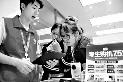 云南省蒙自市一店内工作人员为今年高考考生讲解手机“国补”政策。薛莹莹摄:光明图片.jpg